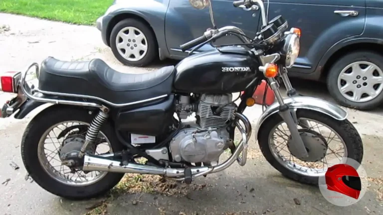 Black Honda CM400 with wire-spoke wheels and drum brakes parked outdoors, side view