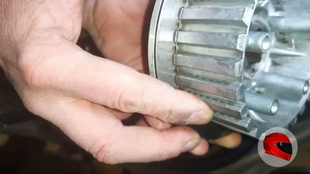 Hands holding a worn Yamaha XJ600 clutch basket during inspection