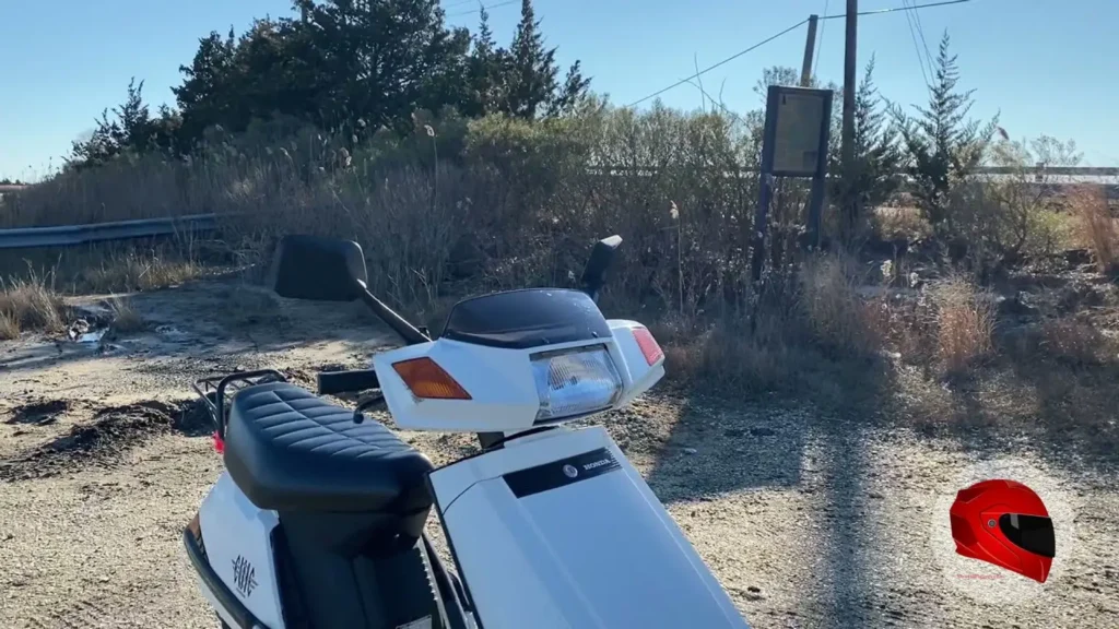 White Honda Elite 80 front three-quarter view showing its rectangular headlight and boxy front fairing