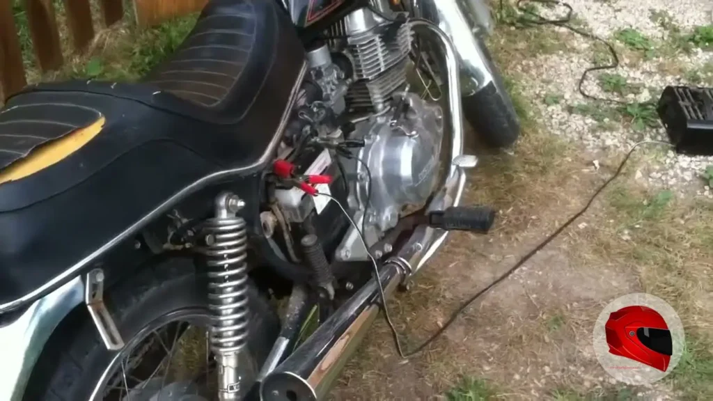Worn 1981 Honda CM400E with a torn seat and jumper cables on the battery
